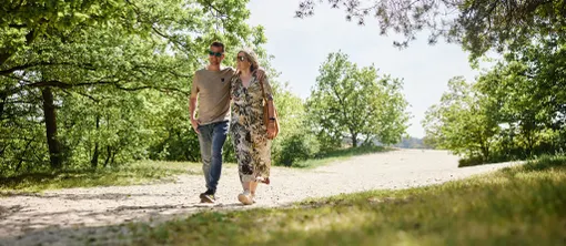 Een wandelend koppel geniet van de rust en de zandvlaktes tijdens een ontspannen wandeling in de Brabantse natuur.
