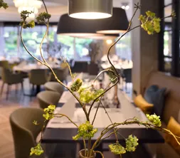 Sfeervol doorkijkje in het modern ingerichte à la carte restaurant, met chique gedekte tafels voor een lunch of diner.