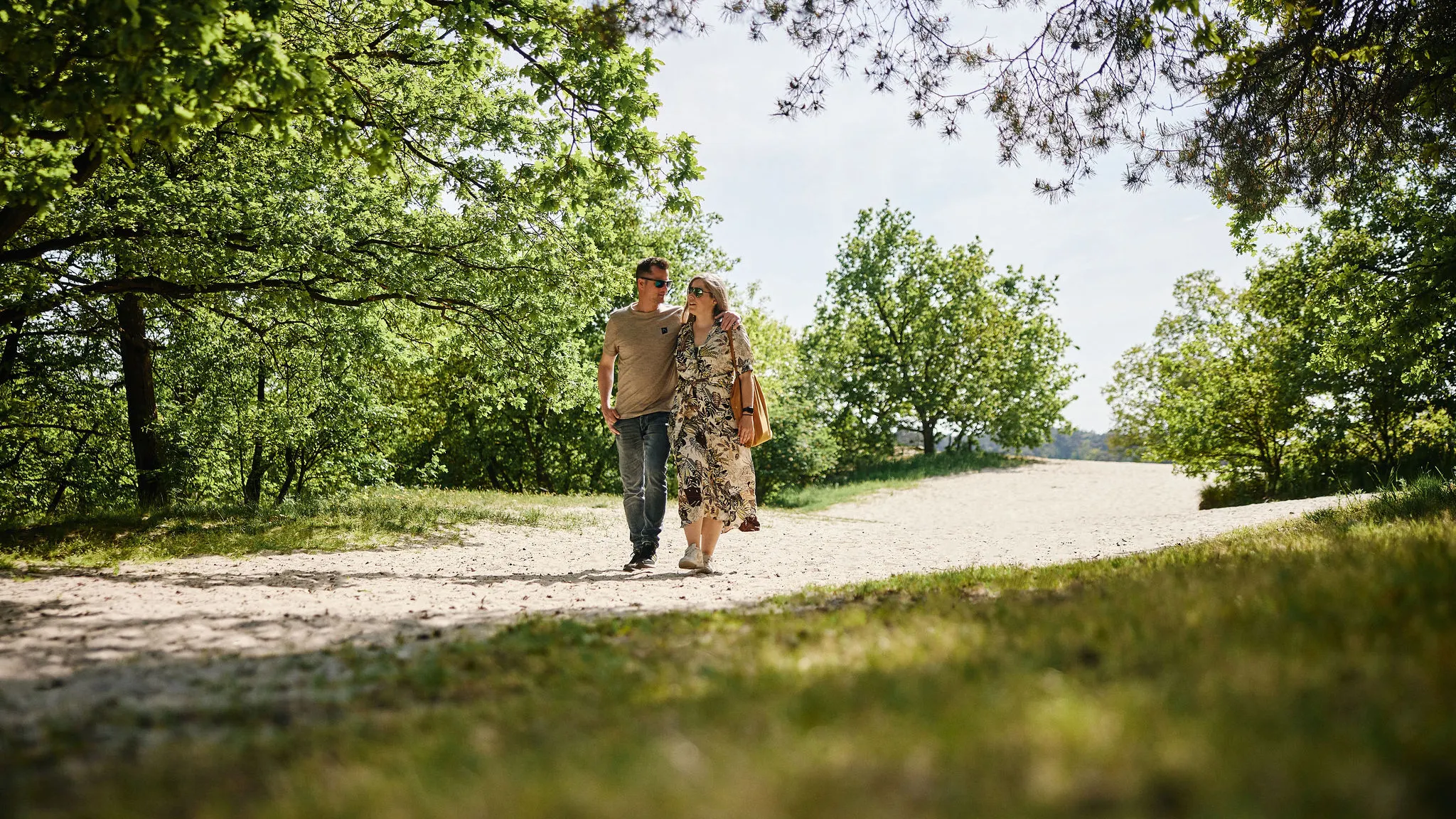 Ein spazierendes Paar genießt die weiten Sandebenen und die bewaldete Umgebung der Loonse und Drunense Duinen.