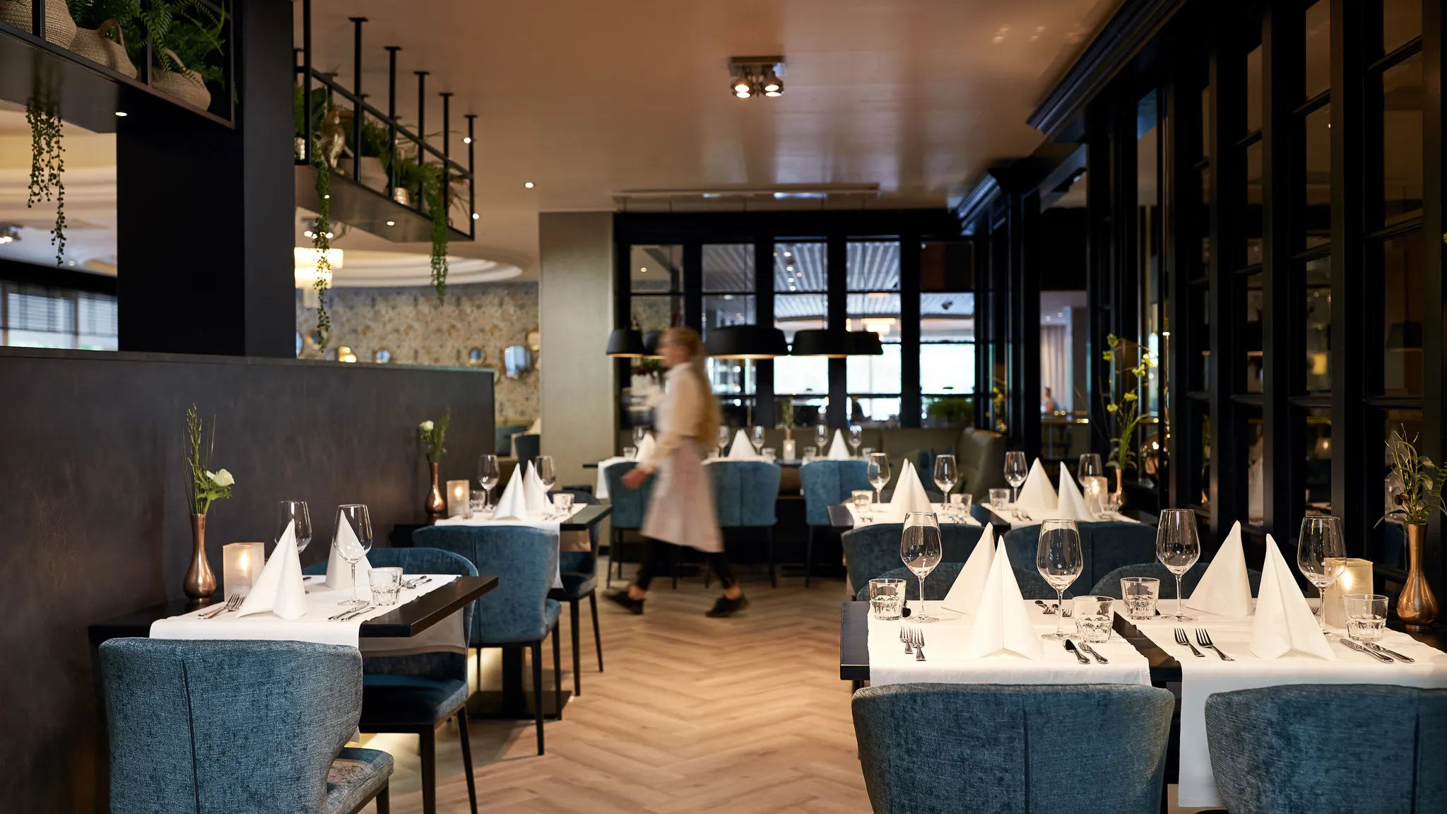 Der stilvoll eingerichtete Restaurantbereich mit elegant gedeckten Tischen ist bereit für das kulinarische Drei-Gänge-Menü.