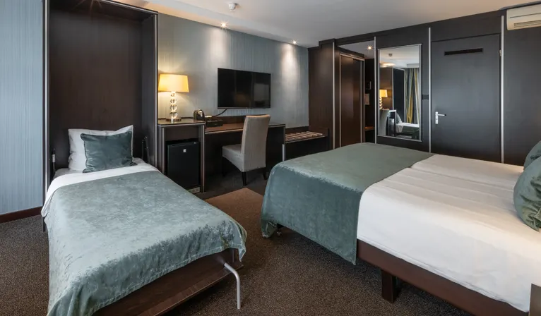 Overzicht van de 3-persoons Comfort Kamer, ingericht met een comfortabel twin bed en een extra, apart eenpersoonsbed