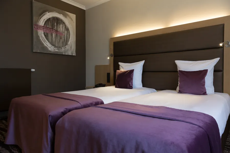 Intérieur moderne de la chambre économique avec lits jumeaux à Nivelles