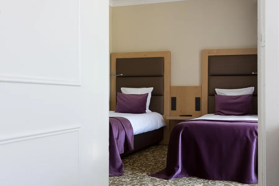 Coin enfant avec deux lits simples dans la chambre familiale